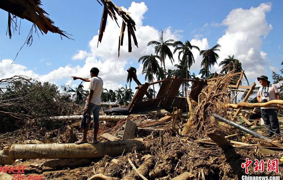 在菲南部南阿古桑省一座桥梁旁淤塞的树木，非法砍伐的树木与被洪水连根拔起的树木掺杂在一起。